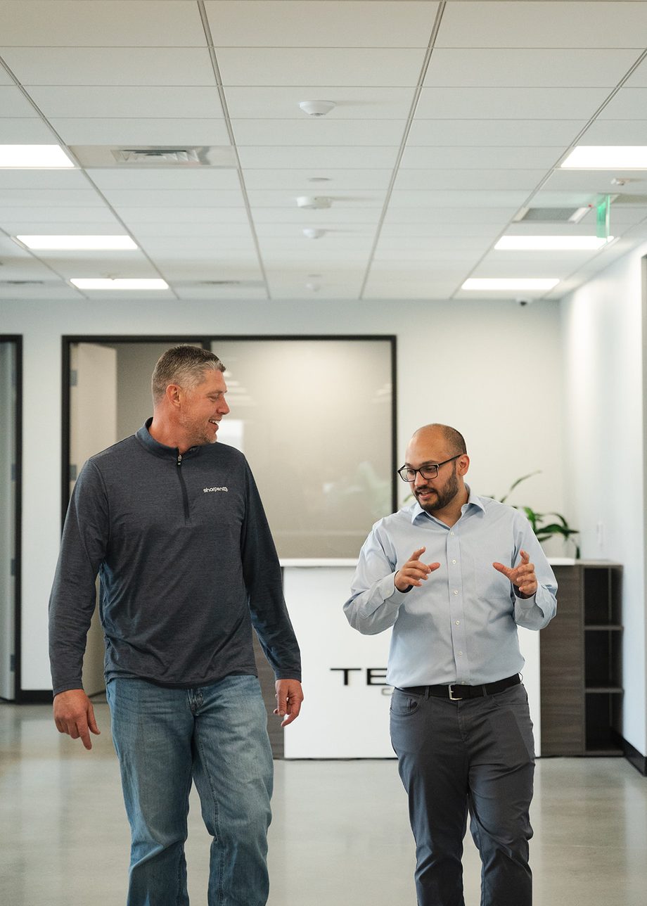 Two TELEO colleagues in conversation while walking through the office